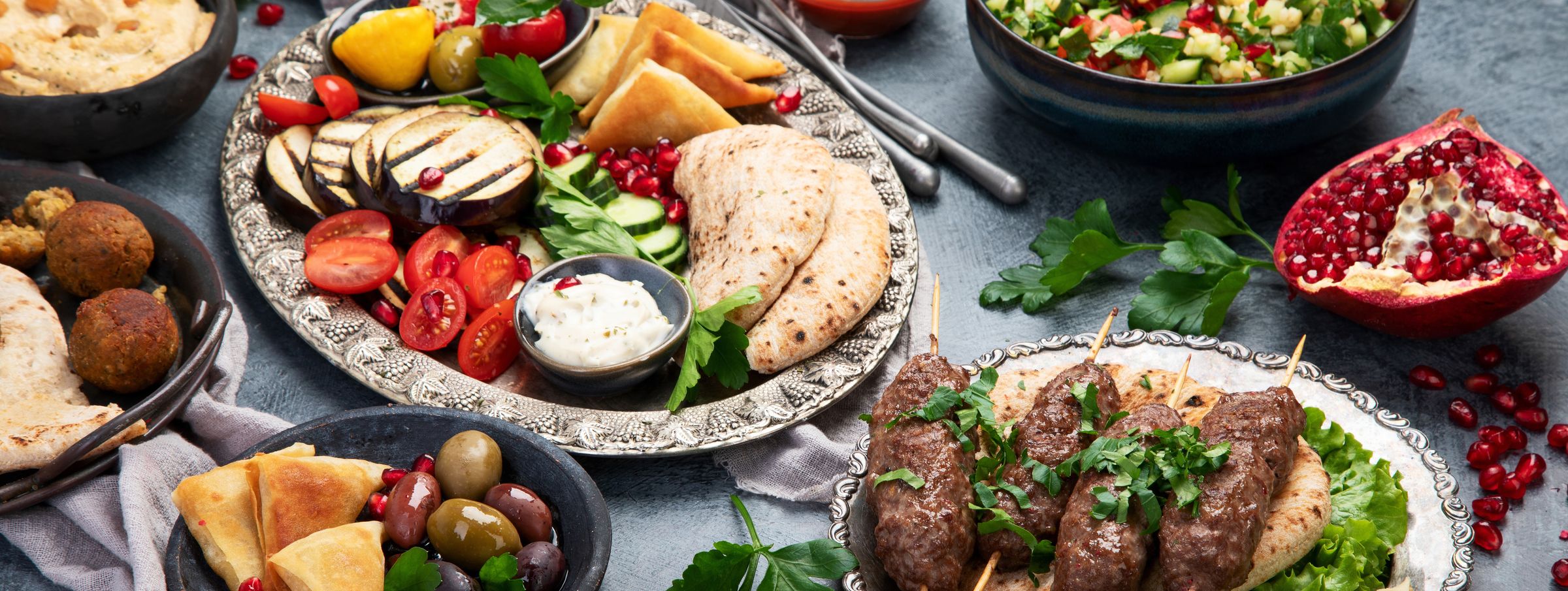 An abundant spread of Middle Eastern dishes across a dark table